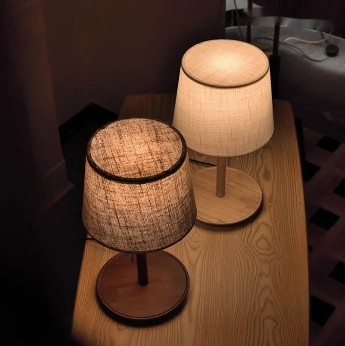 Walnut colour solid wood desk lamp with a white cloth shade and black cable switch.