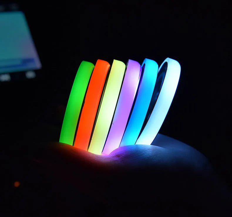 Colourful LED light-up coaster for car cup holder with USB cable on a car centre console.