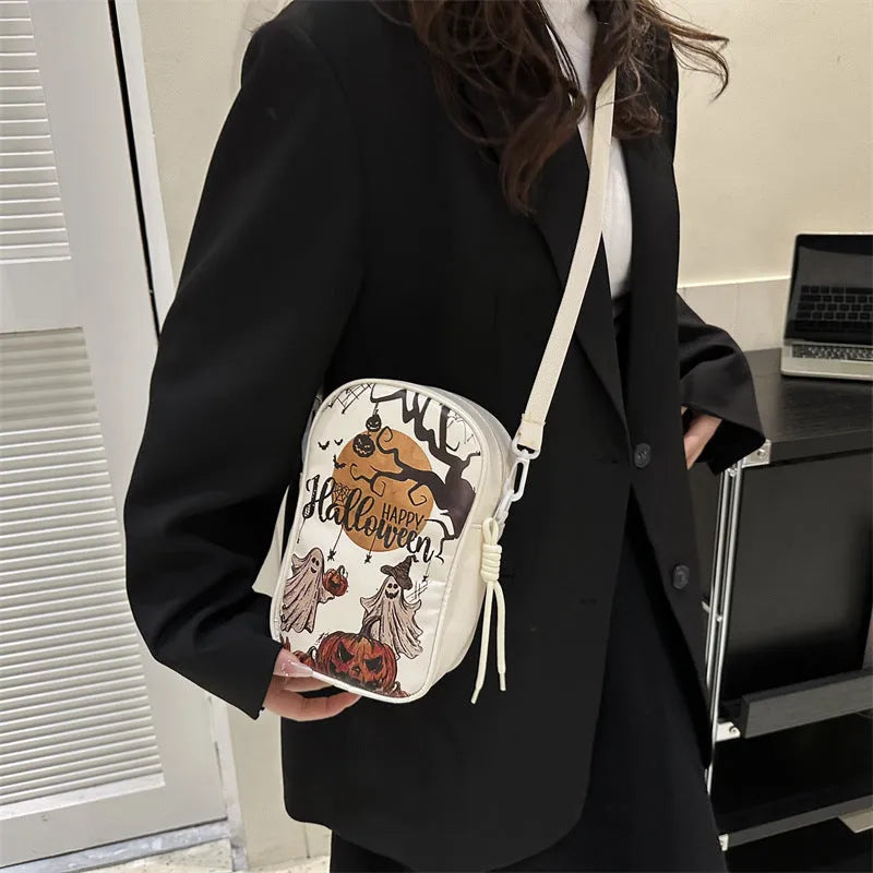 Halloween graffiti crossbody phone bag with cartoon pumpkin, ghost, and bat print in black.