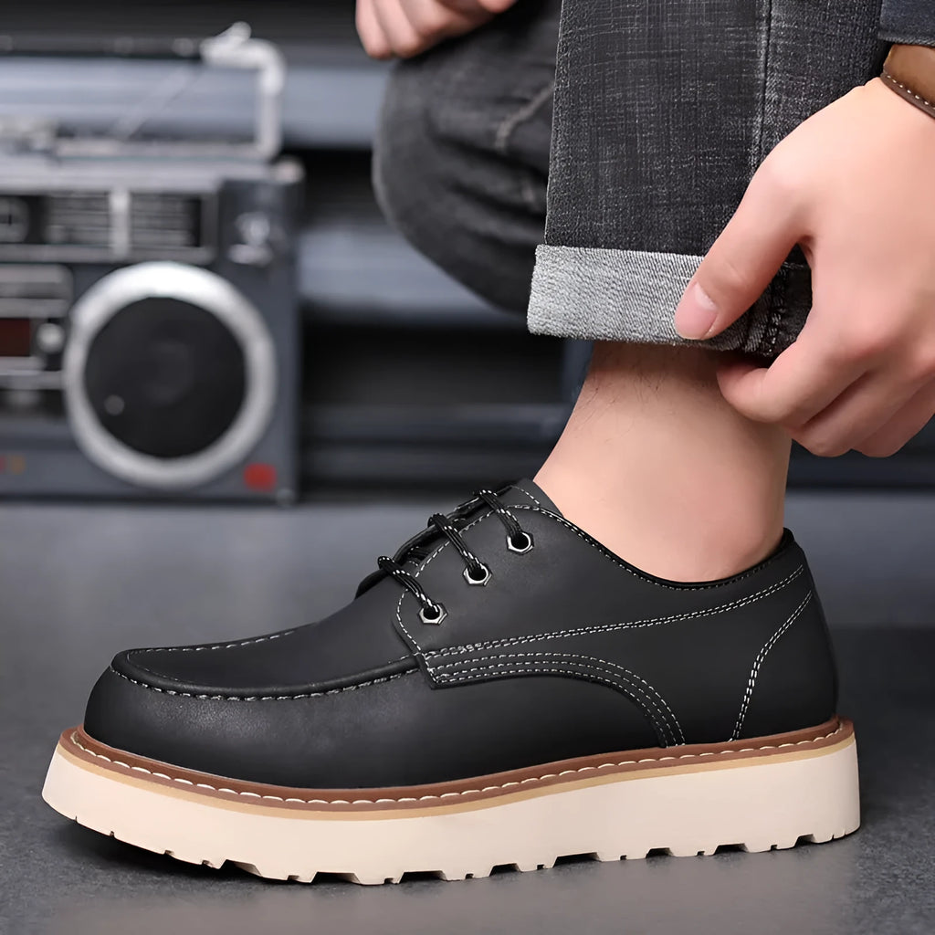 Men's black low-top Martin boots with round toe and rubber sole on a neutral background.