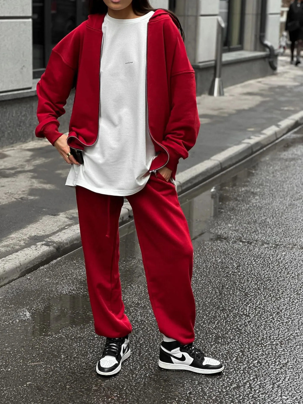 Red loose fit two-piece suit comprising a long-sleeved coat and trousers on a rack.