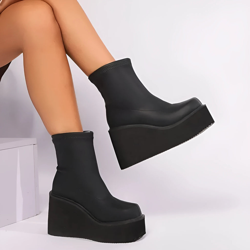 Plus size black women's boots with a wedge heel, round toe, and waterproof platform.