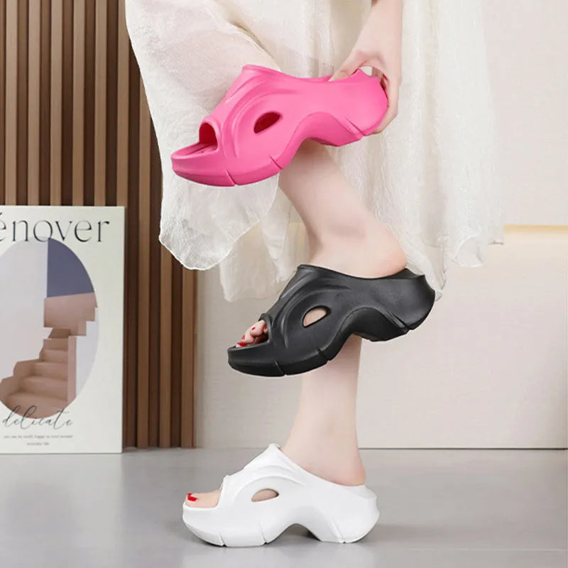 Women's white thick-soled EVA beach slippers with round toe on sand.
