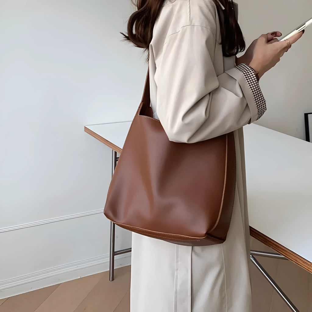 Women's soft PU leather shoulder bag with swing threads design in black or brown, showing 28x32x12cm dimensions