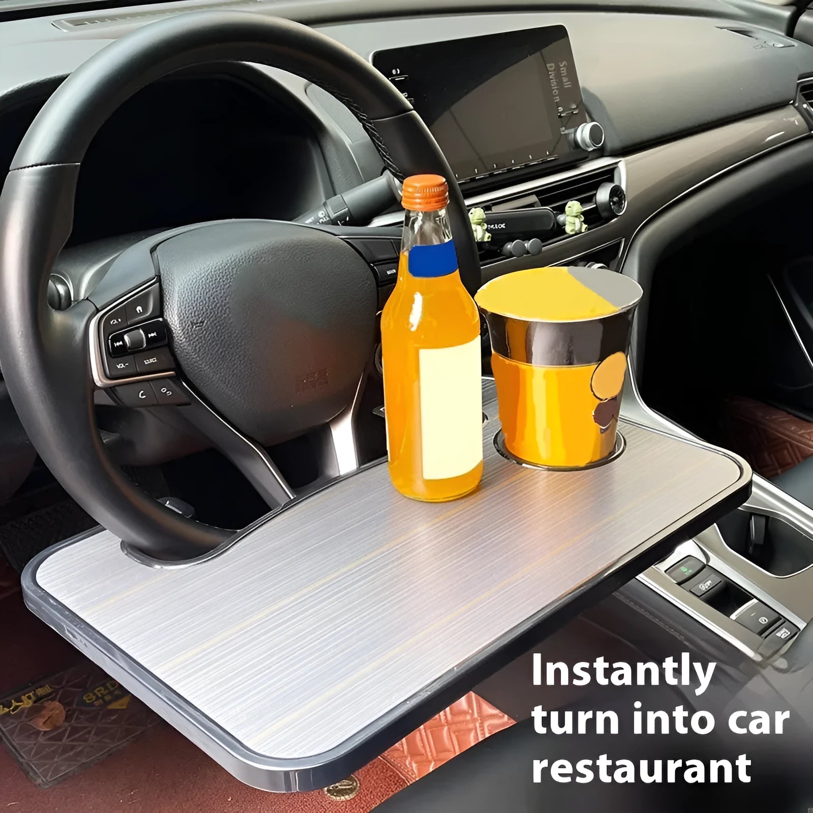 Foldable black car laptop stand with integrated drink holder placed on steering wheel