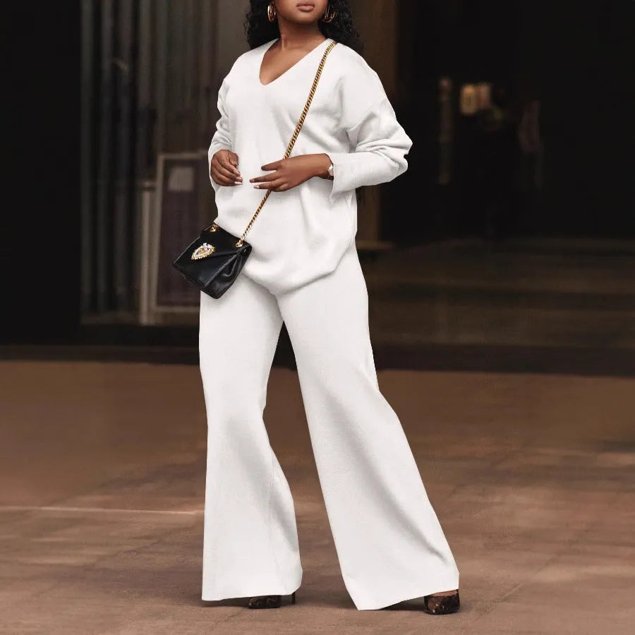Women's brown suede two-piece suit with split sleeve top and full-length trousers on a model.