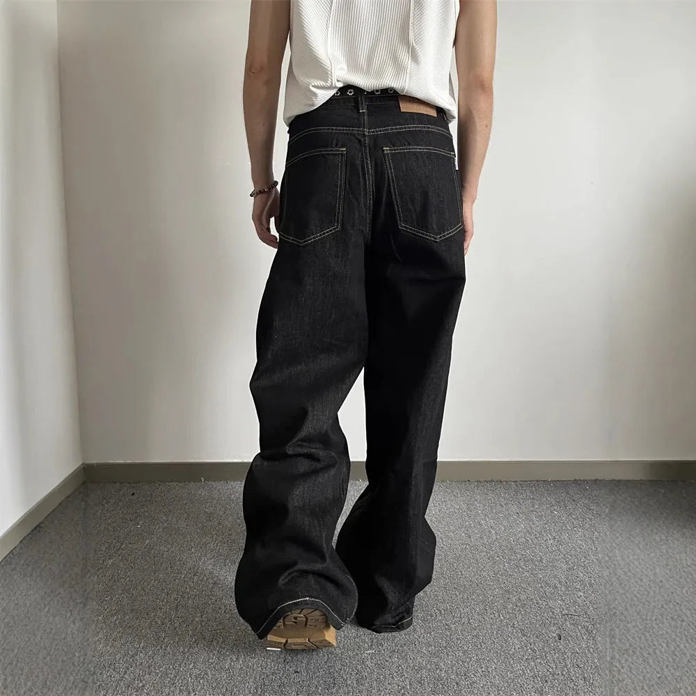 Black loose wide-leg straight-leg retro jeans on a hanger, showing zip fly and mid waist.