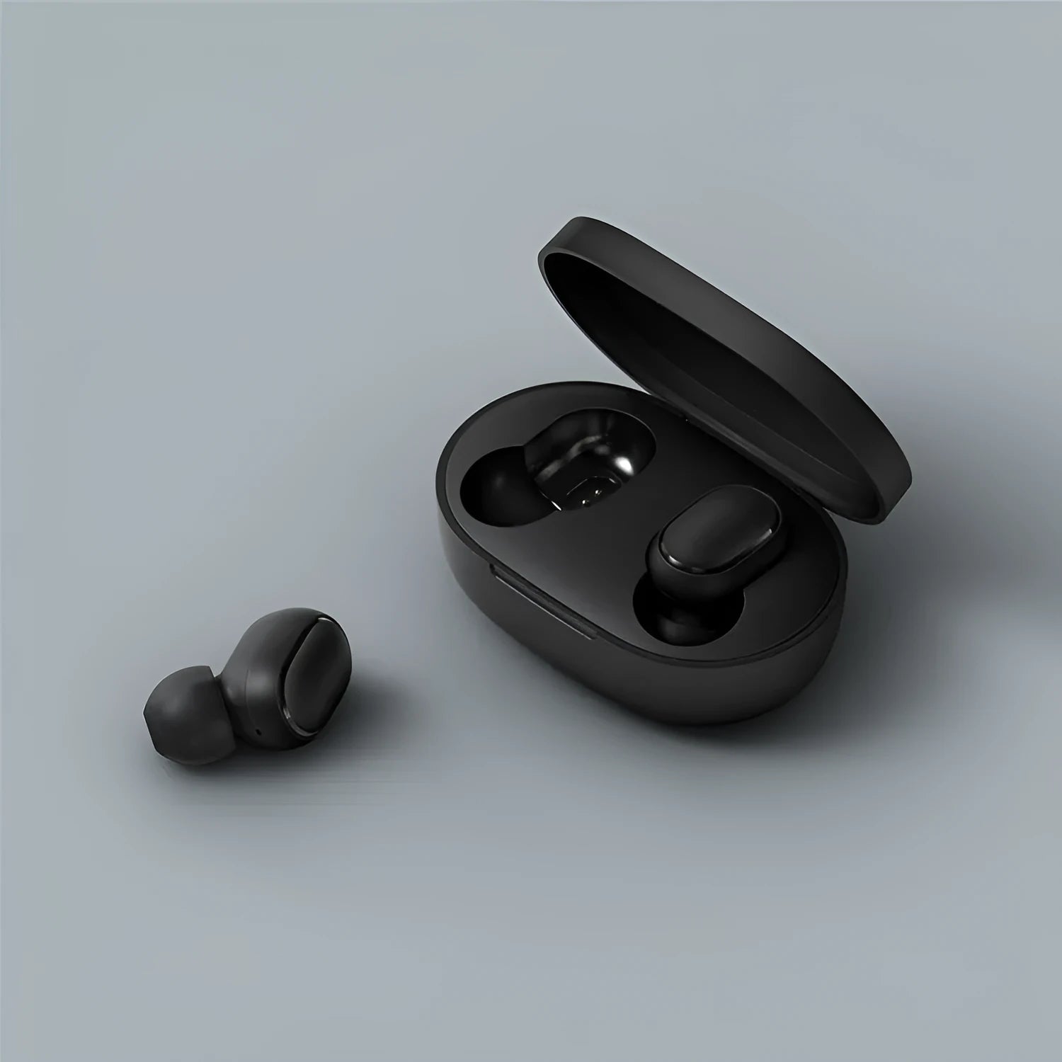 Redmi AirDots black true wireless earbuds next to their compact white charging case.