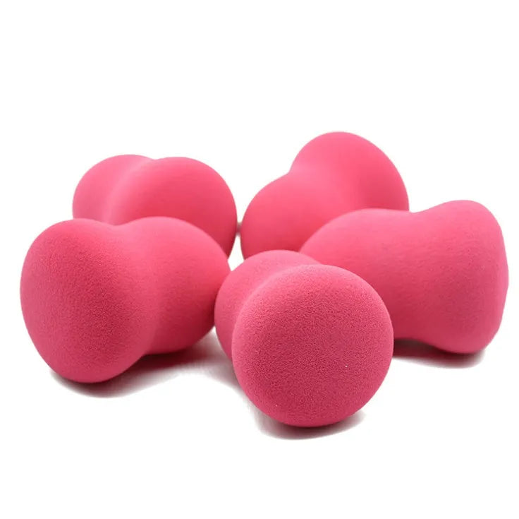 Pink makeup foundation sponge puff on a white background, showing its cubic shape and size.