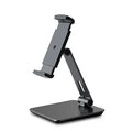 Black folding aluminium desktop stand holding a tablet at an angle, showing 360° rotation and silicone grips.