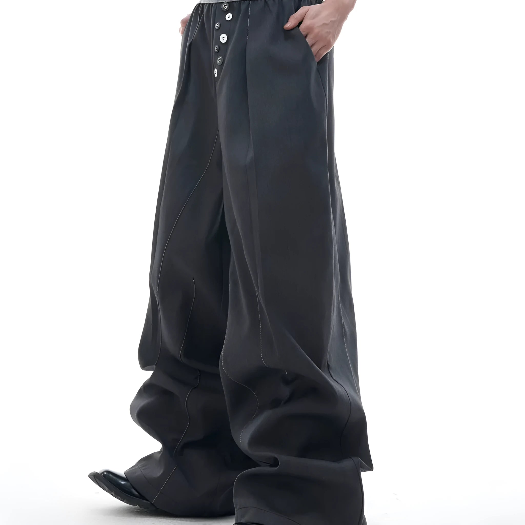 Drooping straight suit pants in black and grey colours showing high waist and button open line design detail.