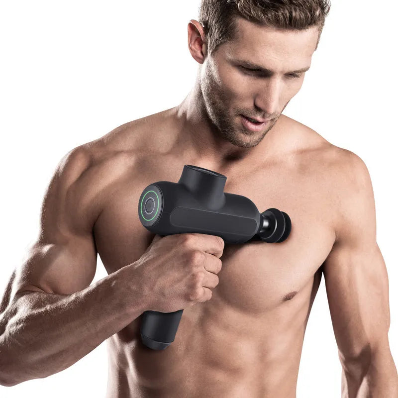 Black rechargeable massage gun with six different coloured massage heads laid out beside it.