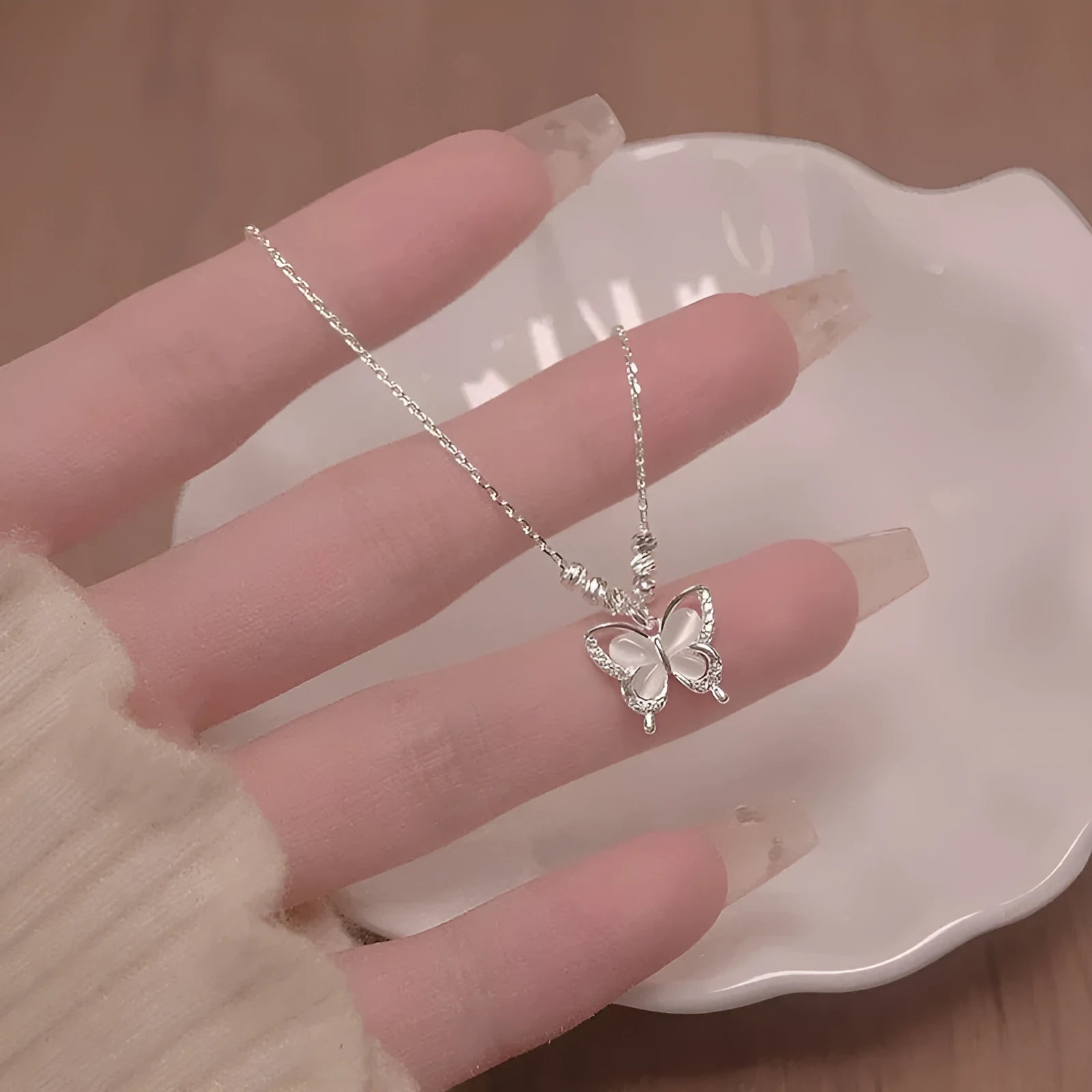Women's silver butterfly necklace on a cross chain, made from 925 sterling silver with an adjustable length.