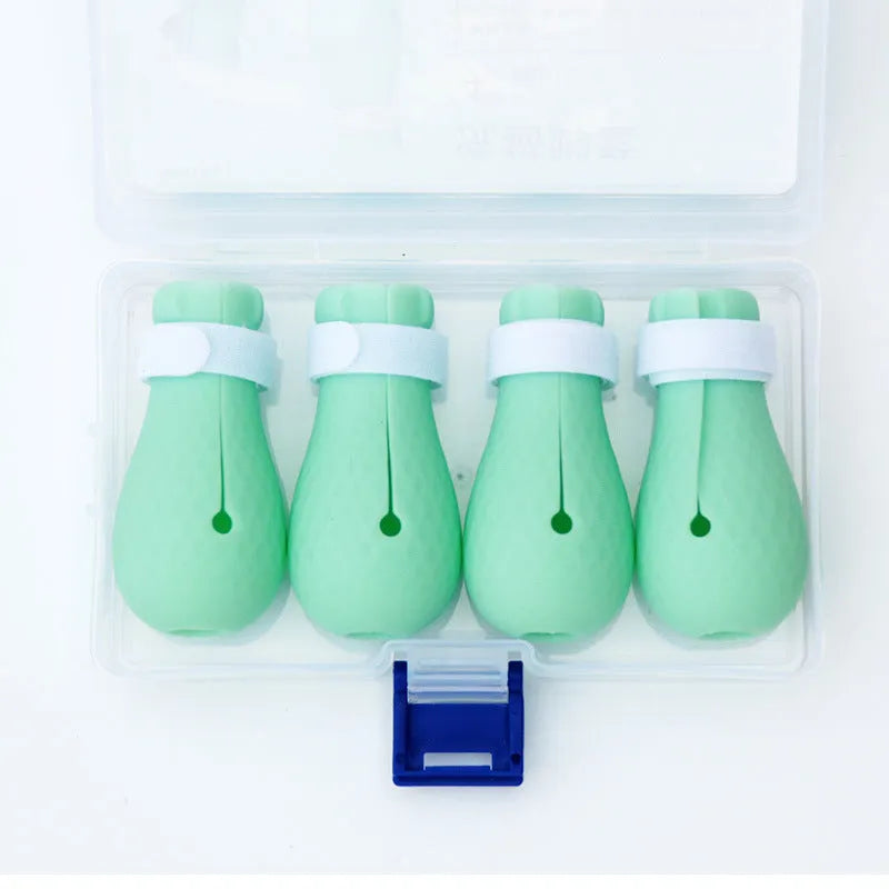 Four green silicone cat paw scratch protection covers for pet grooming.