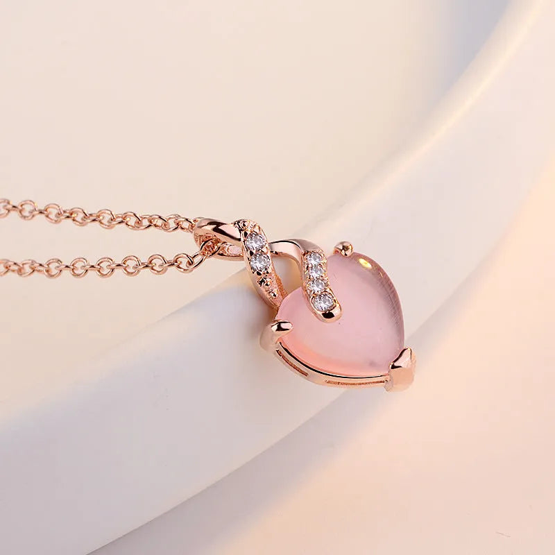 Women's heart-shaped pink synthetic crystal pendant necklace on rose gold cross chain