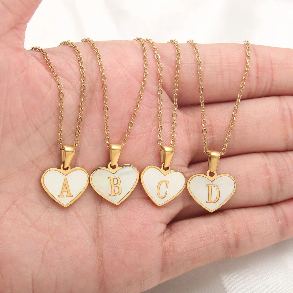 Gold-plated heart necklace with white shell centre on an adjustable stainless steel chain.