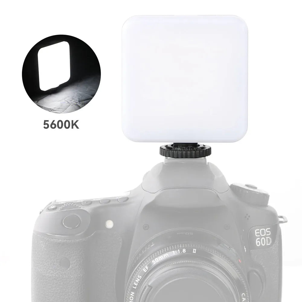 Compact black LED mini square camera flash with hot shoe mount on a small tripod stand.