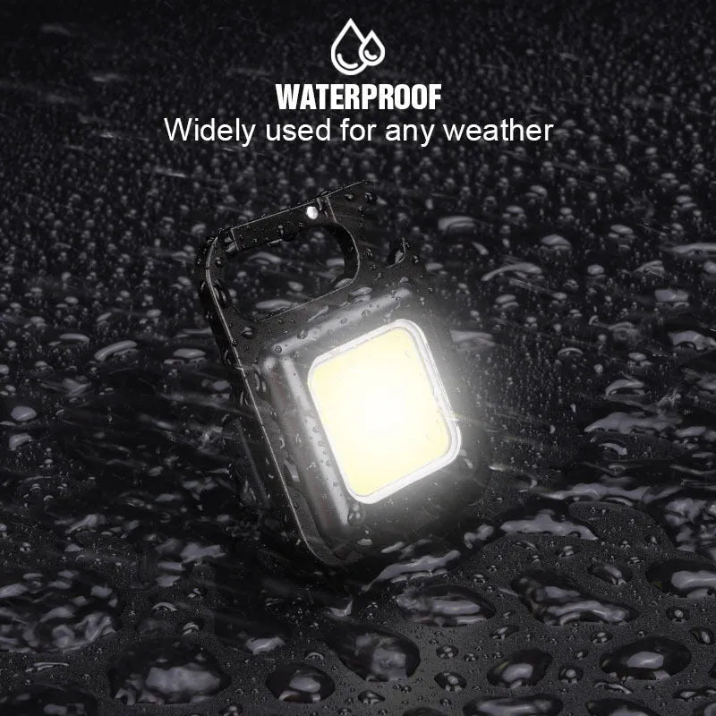 Black aluminium alloy USB rechargeable keychain torch with magnetic base and foldable handle.