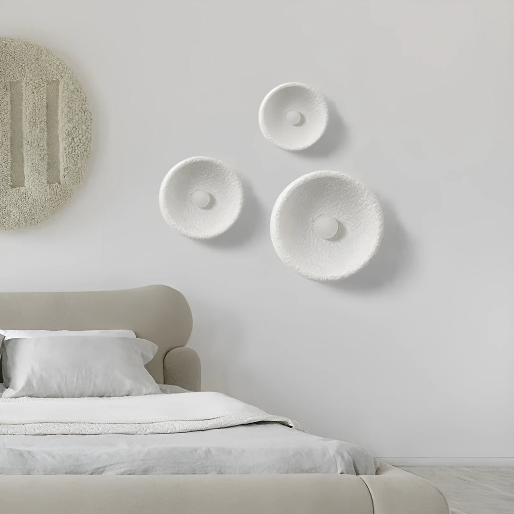 Japanese minimalist wall lamp with a round resin shade, shown in a modern room setting.