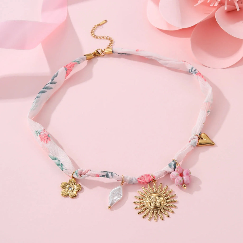 Stainless steel women's necklace with a sun pendant on a regular chain, showing heart and ribbon sun design options.