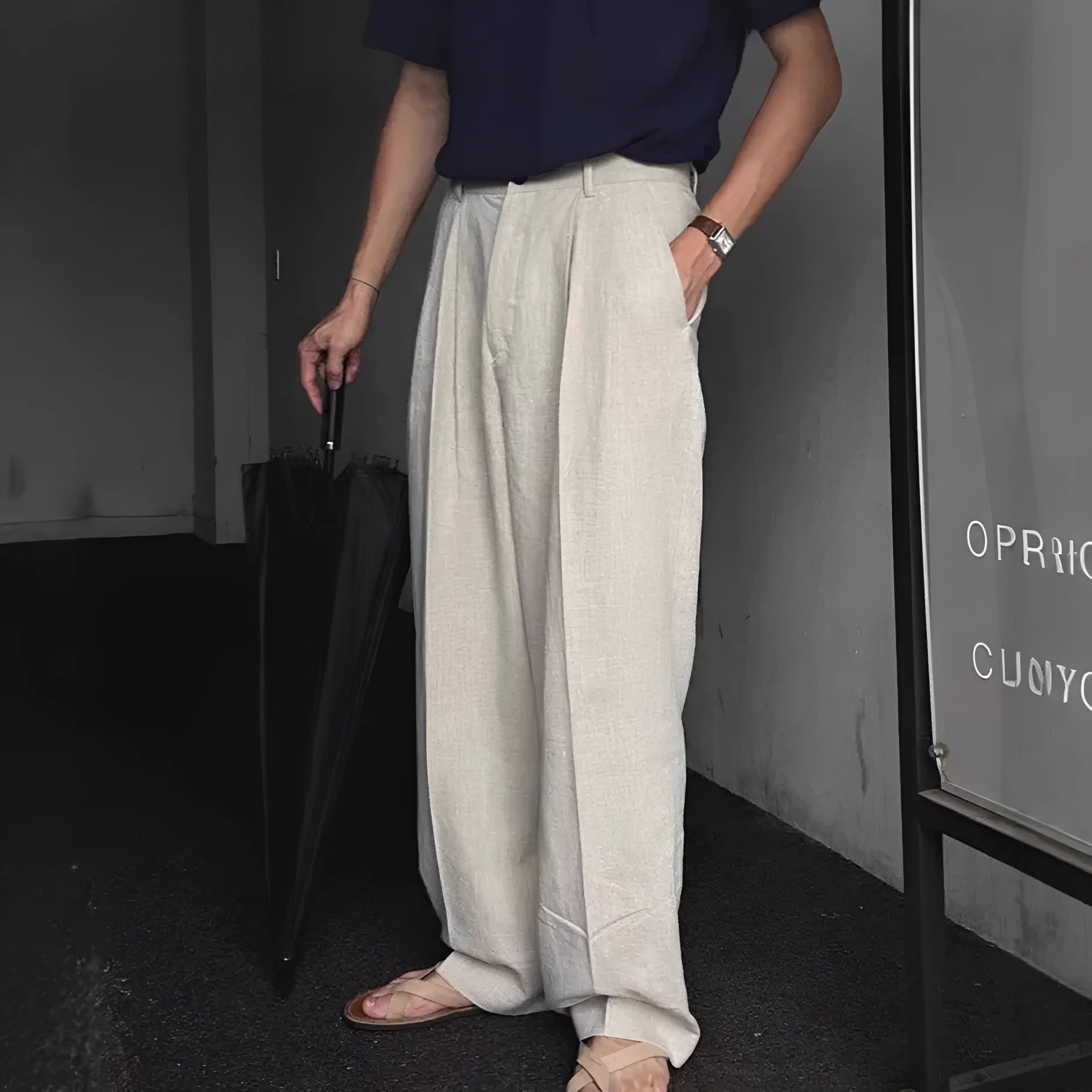 Man wearing apricot wide-leg cotton linen trousers with a mid waist and zip fly.