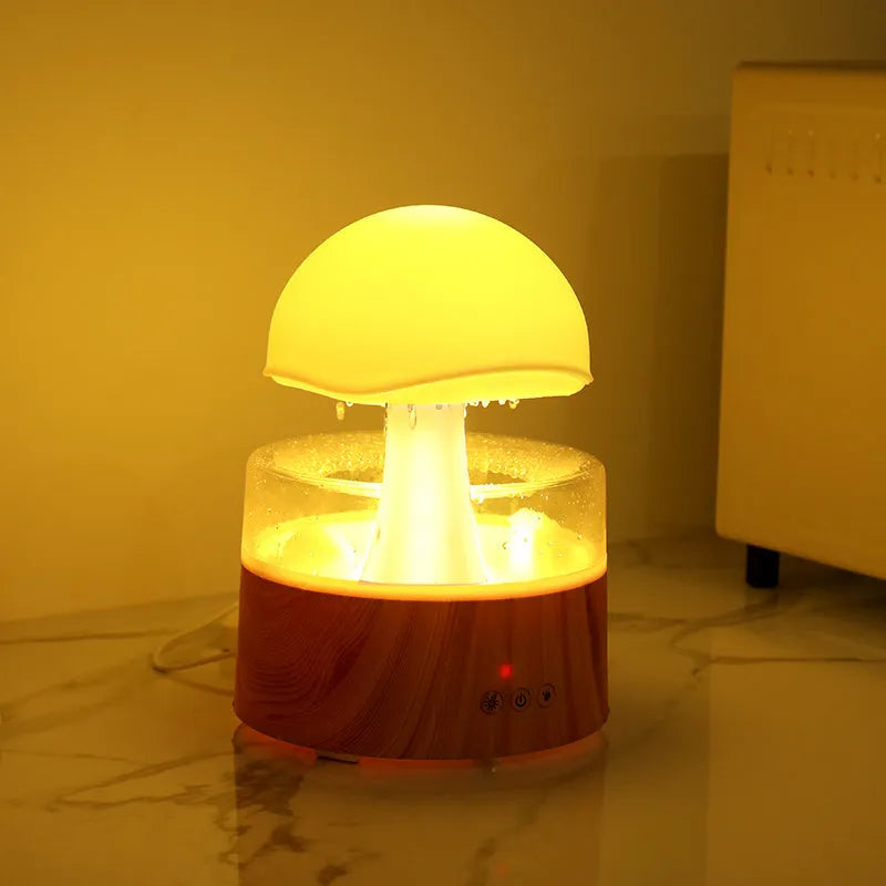 White cloud-shaped humidifier with LED lighting and raindrop simulation on wooden surface