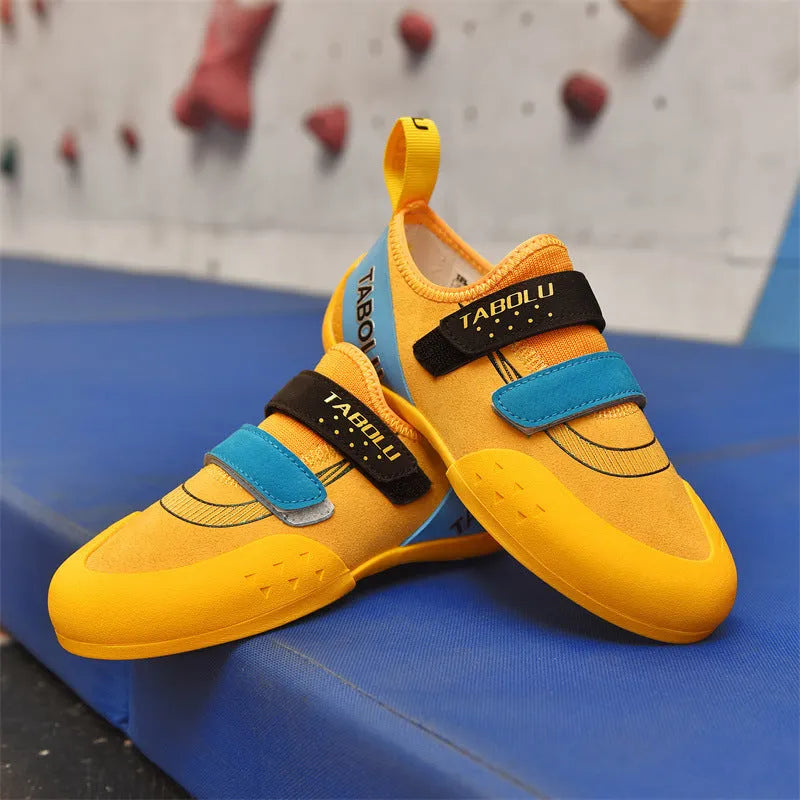 A pair of Velcro closure rock climbing shoes with a non-slip rubber sole in a black and red colour scheme.