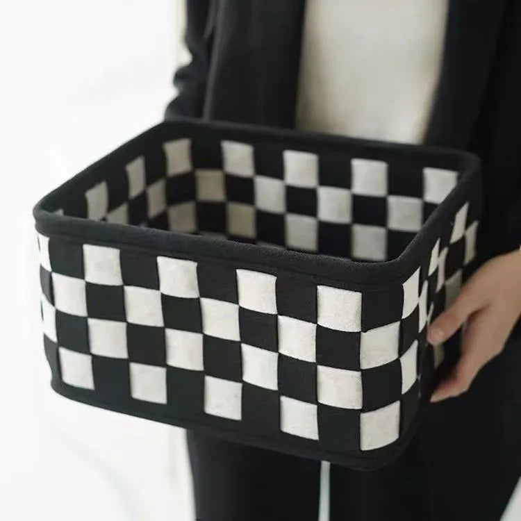 Checkerboard pattern black and white felt storage basket with folded sides.