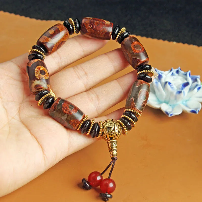 Close-up of a handmade Tibetan dzi bead bracelet with distressed agate beads in antique and frosted finishes.