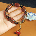 Close-up of a handmade Tibetan dzi bead bracelet with distressed agate beads in antique and frosted finishes.