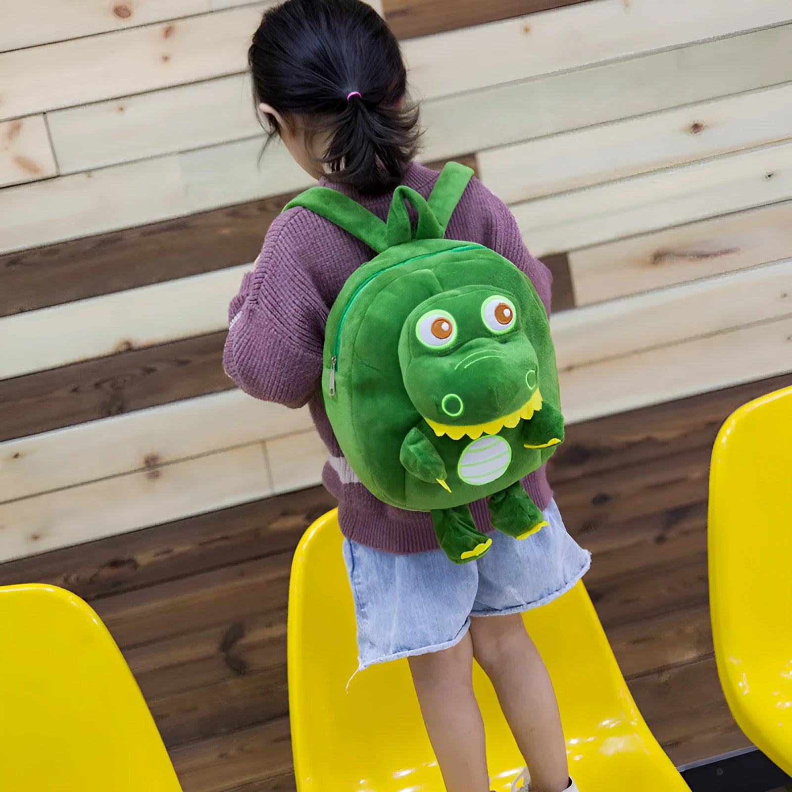 Blue dinosaur plush backpack for children with embroidery detail and soft handle