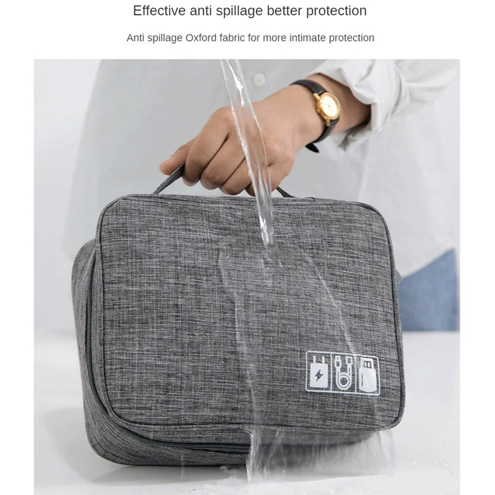 Black waterproof electronics organiser bag open to show removable dividers and mesh pockets for cables.