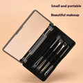 Makeup brush set with mirror open, showing silver and gold eyeshadow brushes inside a compact case.
