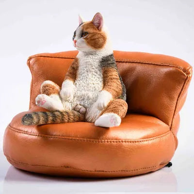 Small lazy cat figurine with sofa car ornament on a dashboard