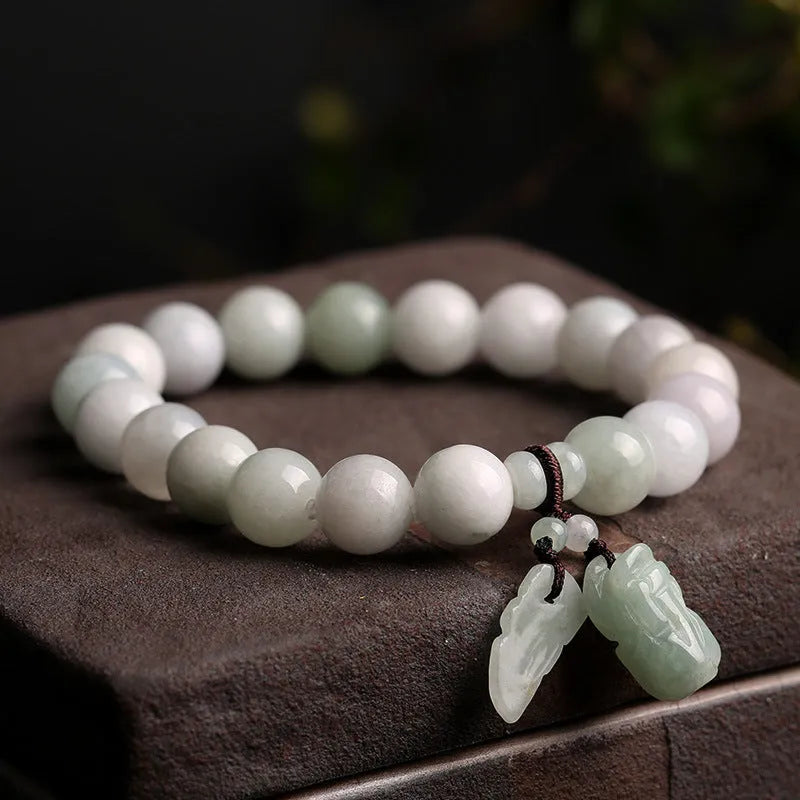 Natural green jade hanging bracelet with Maitreya Buddha pendant on a wrist.