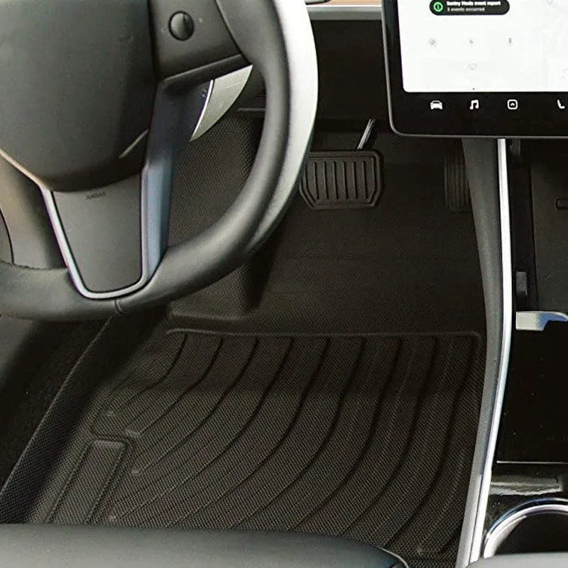 Black rubber floor mat for Tesla car interior with textured TPE footrest section.