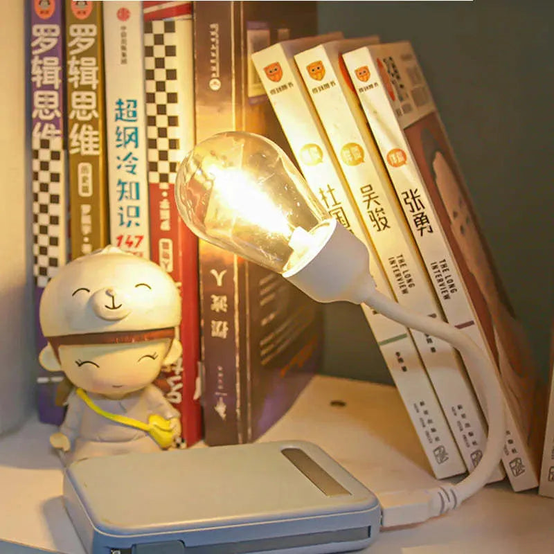 A folding USB rechargeable night light with a warm white tungsten filament S14 bulb visible.