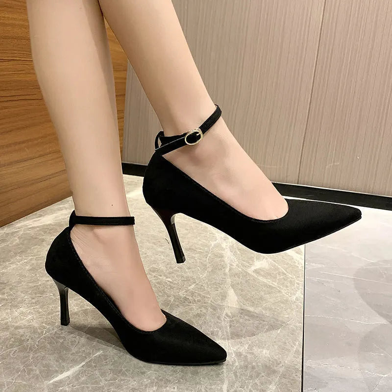 Black and creamy white women's stiletto heel pumps with a skull pattern and ankle buckle.