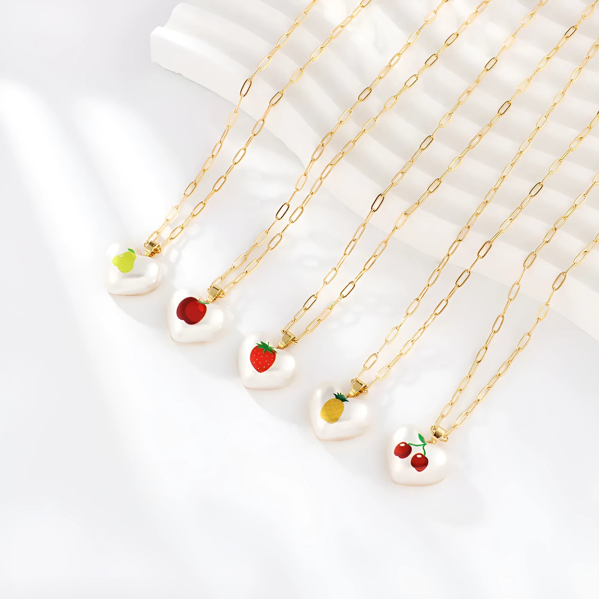 Adjustable chain necklace with a choice of geometric fruit pendant charms: apple, cherry, pear, pineapple, or strawberry.