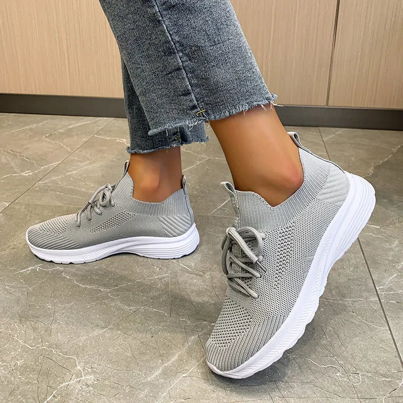 Women's mesh running shoes in creamy white with Flyknit upper and rubber sole