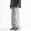 Men's light blue washed straight leg jeans with button waist closure on a plain background.