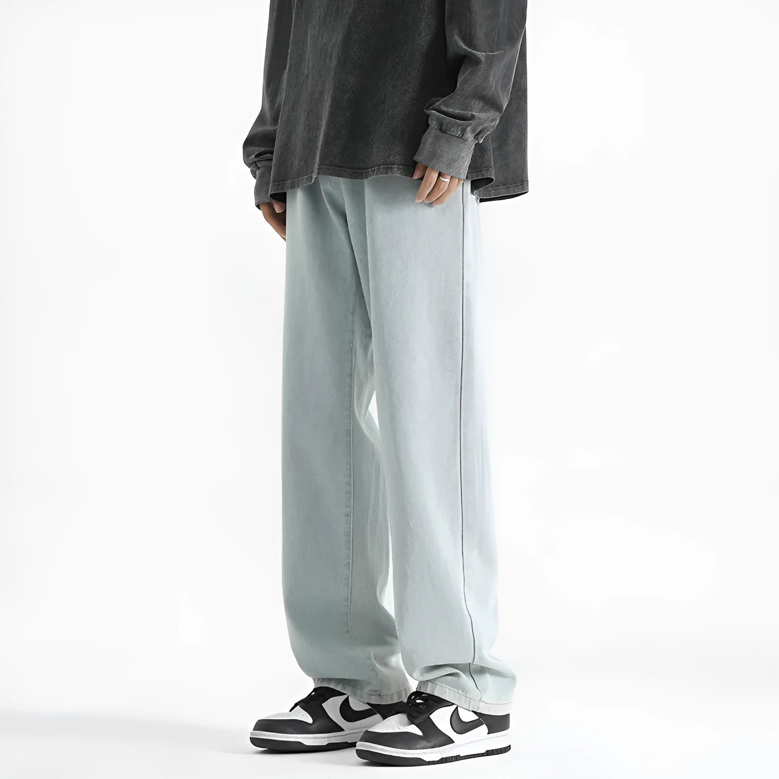 Men's light blue washed straight leg jeans with button waist closure on a plain background.