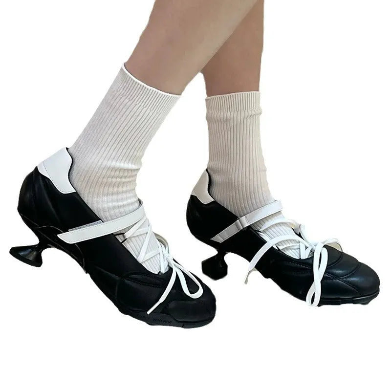 Women's silver lace-up sports shoes with a bow detail and a round toe, shown on a low-top cut.
