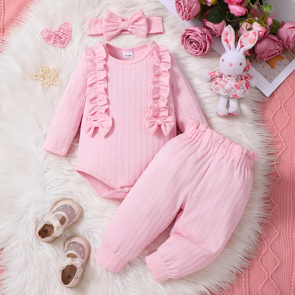 Pink baby girl three-piece set with ribbed frill long sleeve romper, pants, and matching headscarf on white background