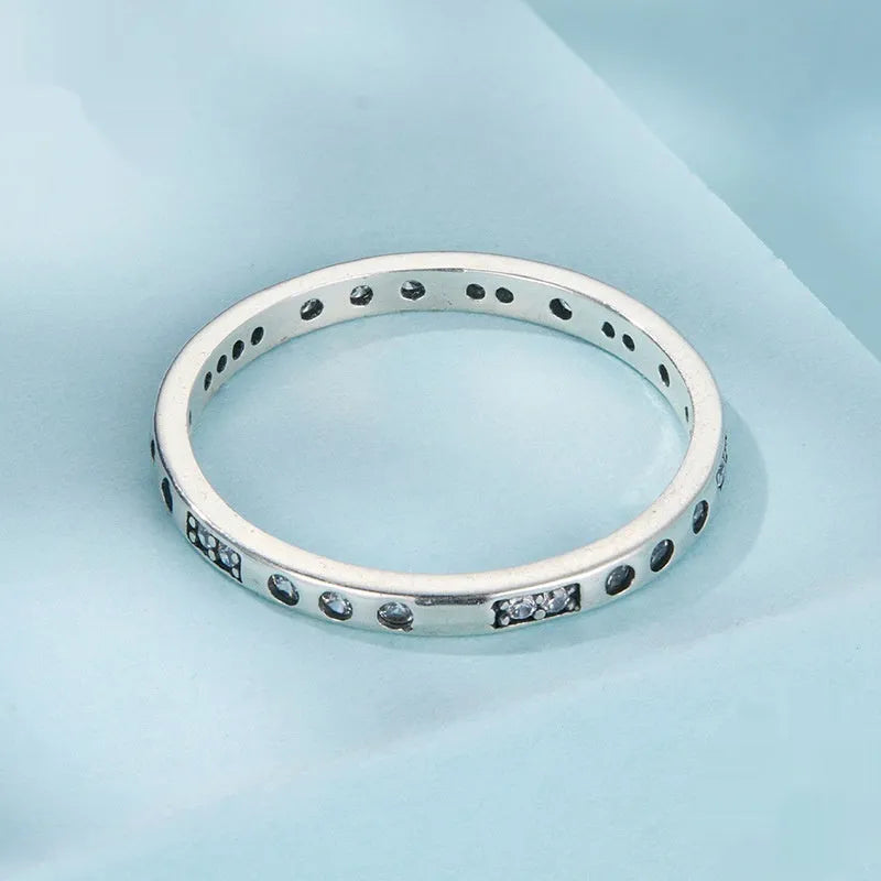 Moss Password I Love You silver ring with oxidised black finish on a model's finger, showing simple bracelet style.
