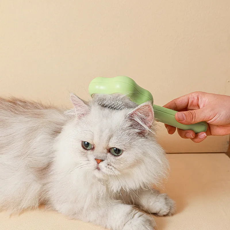 Green self-cleaning stainless steel cat comb with needle teeth on a 20cm handle.