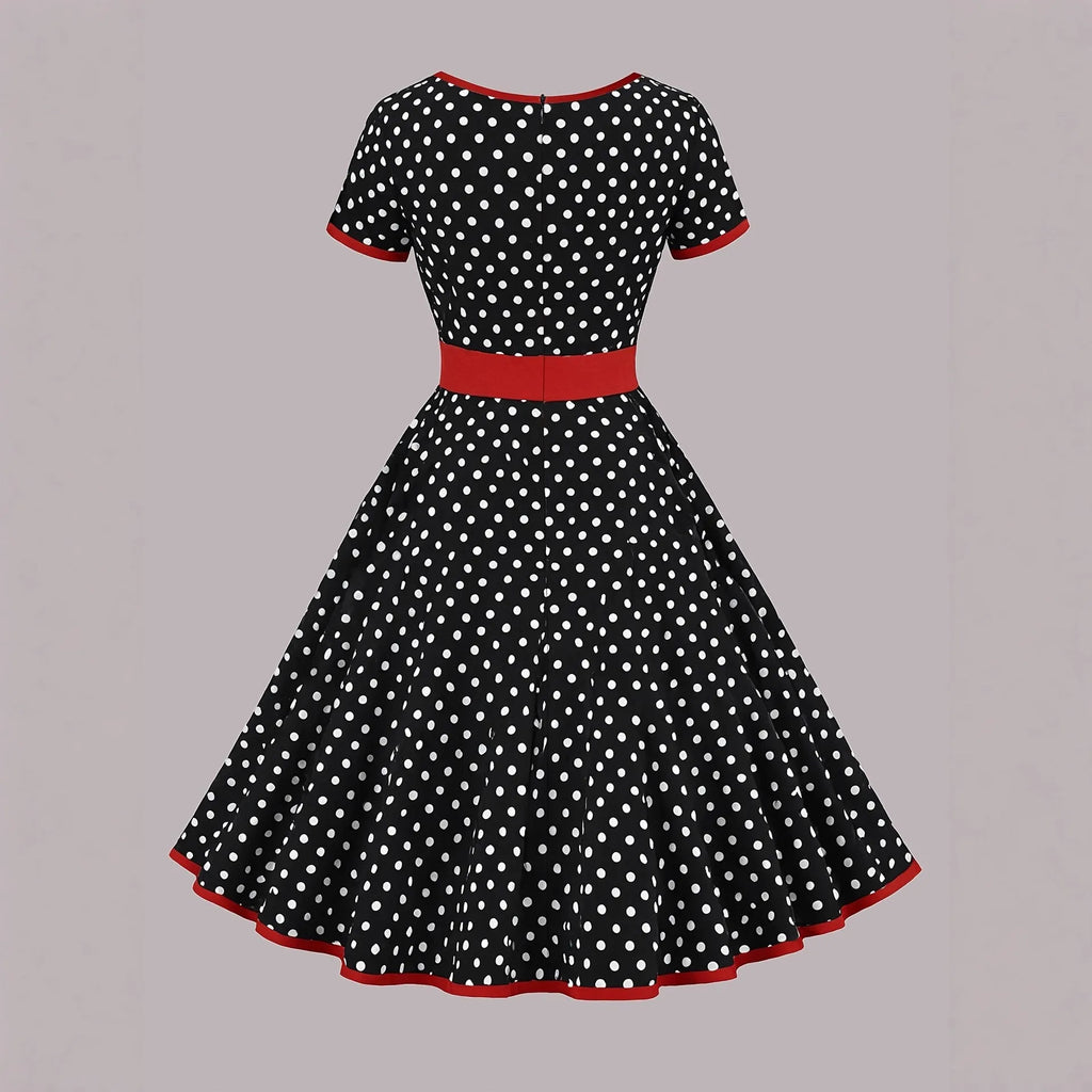 Square collar short sleeve polka dot dress with pleats and a zip on a mid-length skirt.