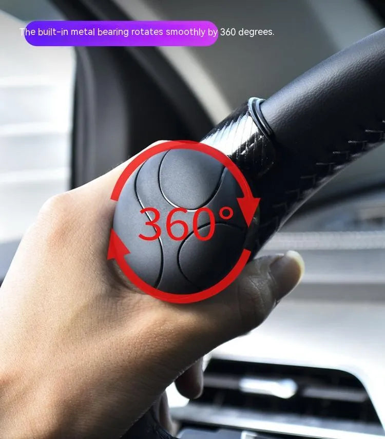 Black and blue silicone steering wheel assist ball with metal bearing, shown at approx 9x6 cm.