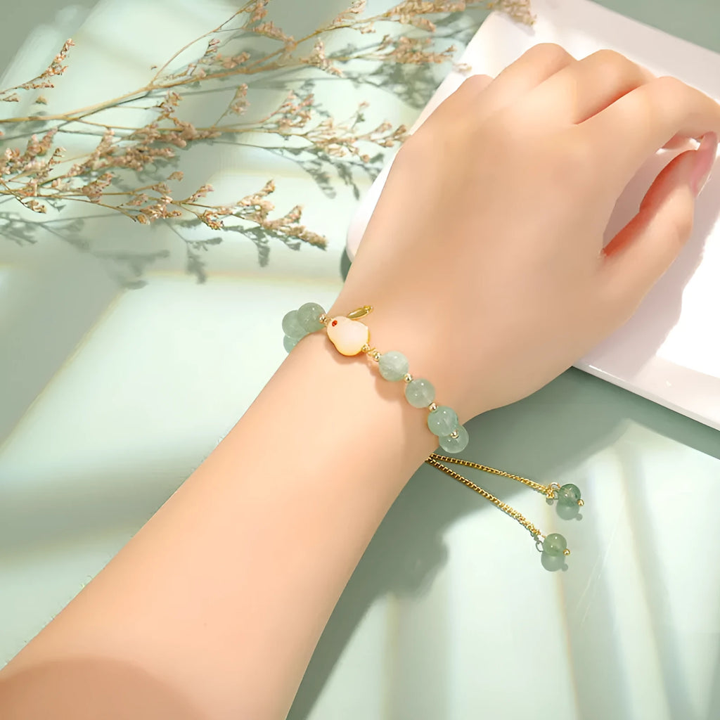 Rabbit charm bracelet with green aventurine and strawberry quartz stones on copper metal with gold accents