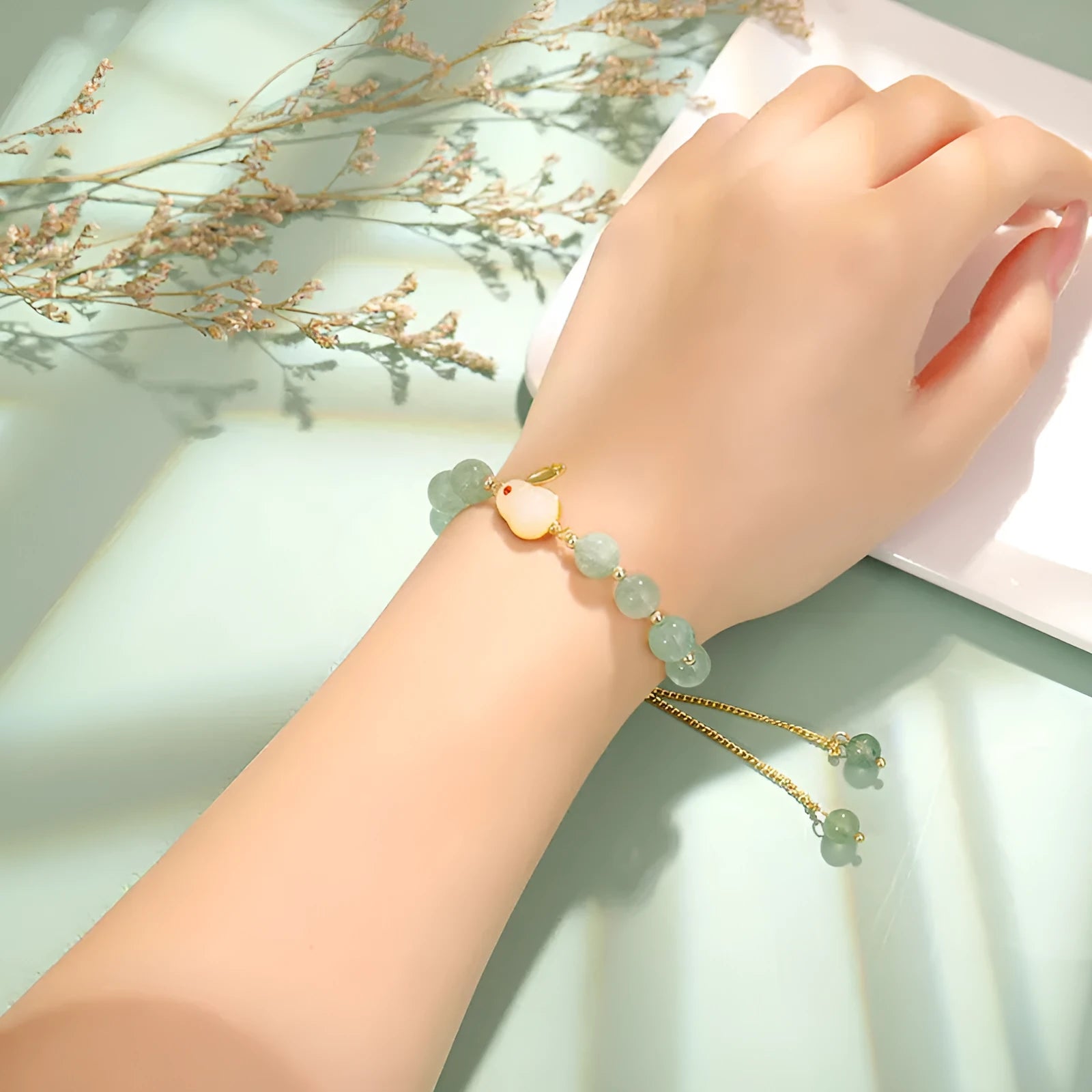 Rabbit charm bracelet with green aventurine and strawberry quartz stones on copper metal with gold accents